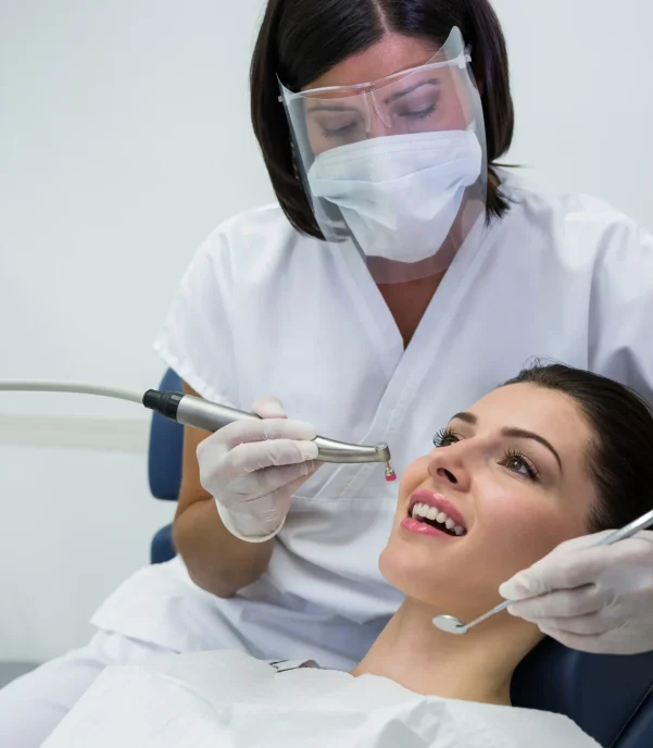 dentist-examining-female-patient-with-tools